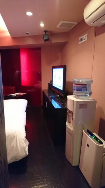HOTEL THE SCENE(ザ・シーン)(横浜市港北区/ラブホテル)の写真『502号室 トイレの方に曲がらず部屋に向かった景色。右手前から空気清浄機、ウォーターサーバー、テレビ、上にエアコン。左にベッドが見える』by なめろう