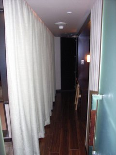 アラウダリゾート国立(国立市/ラブホテル)の写真『209号室 通路 （カーテンで区切られ、左手に浴室やトイレ、右手にベッド、奥に冷蔵庫やウォーターサーバ）』by ホテルレポったー