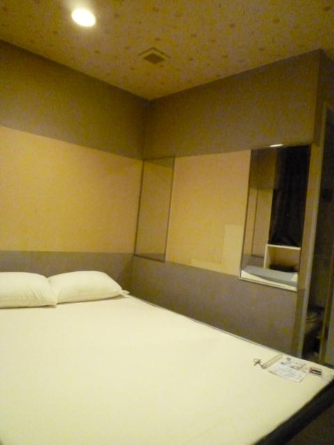 HOTEL i（アイ）(新宿区/ラブホテル)の写真『403号室椅子側から見た部屋。ベッドが壁にぴったり付いています。鏡があるせいかやや広く見えます。』by 格付屋