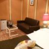 ホテルSAVOY(台東区/ラブホテル)の写真『405号室（ベッド方向からの写真です。二人掛けのソファとガラステーブルがあります。外付けエアコンと絵）』by 格付屋