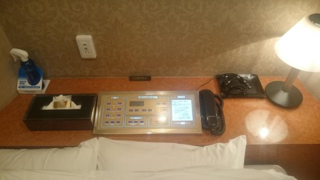 HOTEL WILL Bay Resort(船橋市/ラブホテル)の写真『402号室　ベッド上部の備品類（左からリセッシュ、ティシュボックス＆Ｇ、コントロールパネル、電話機、携帯電話・スマホ充電端子、電気スタンド）』by YOSA69