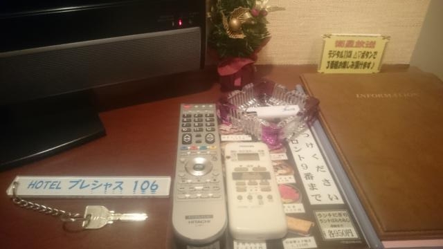 ホテル プレシャス(足立区/ラブホテル)の写真『106号室　備品類収納棚の上の冊子類、テレビ・エアコンのリモコン、部屋の鍵』by YOSA69