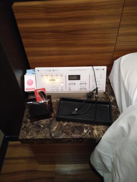 HOTEL CUE厚木(厚木市/ラブホテル)の写真『405号室 ベッドの脇、寝転んで右に照明のスイッチと携帯機器の充電コード、衛生具』by なめろう