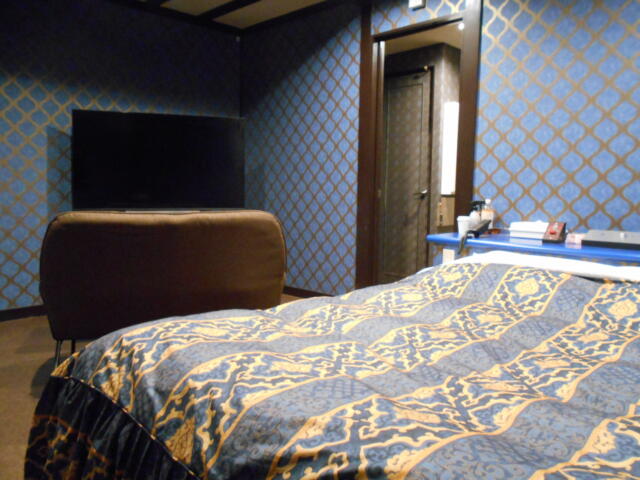 ホテル ゲルマニア(嬉野市/ラブホテル)の写真『108号室、ベッド側から見る。ベッド、ソファ、大型テレビ。』by 猫饅頭