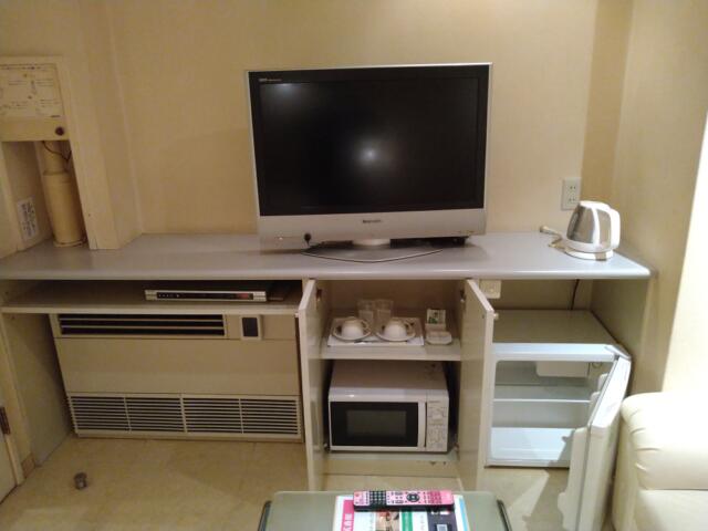 ホテル 貮番館(墨田区/ラブホテル)の写真『505号室 テレビ。その下に左からエアコン、食器類、電子レンジ、持ち込み用の冷蔵庫』by なめろう