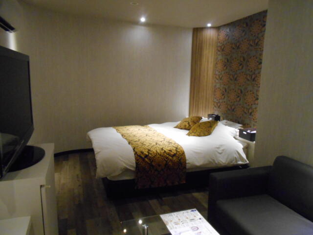 HOTEL M.（エムドット）(嬉野市/ラブホテル)の写真『101号室、ベッドと手前にソファ、左側に大型TVがある』by 猫饅頭