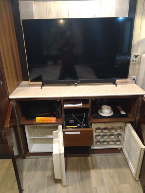 Dispa Resort(ディスパリゾート)(横浜市中区/ラブホテル)の写真『707号室 ベッドの足元にテレビ。その下に食器類、持ち込み用冷蔵庫、販売用冷蔵庫、真ん中の引き出しにカラオケのマイク２本。』by なめろう