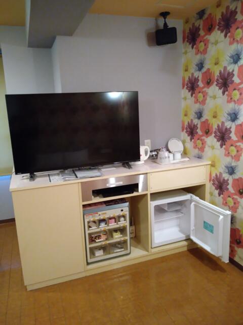 ホテル パルティノン(川崎市川崎区/ラブホテル)の写真『305号室 ベッドの足元にテレビ、横に食器類。その下にオモチャの販売機、持ち込み用の冷蔵庫。』by なめろう
